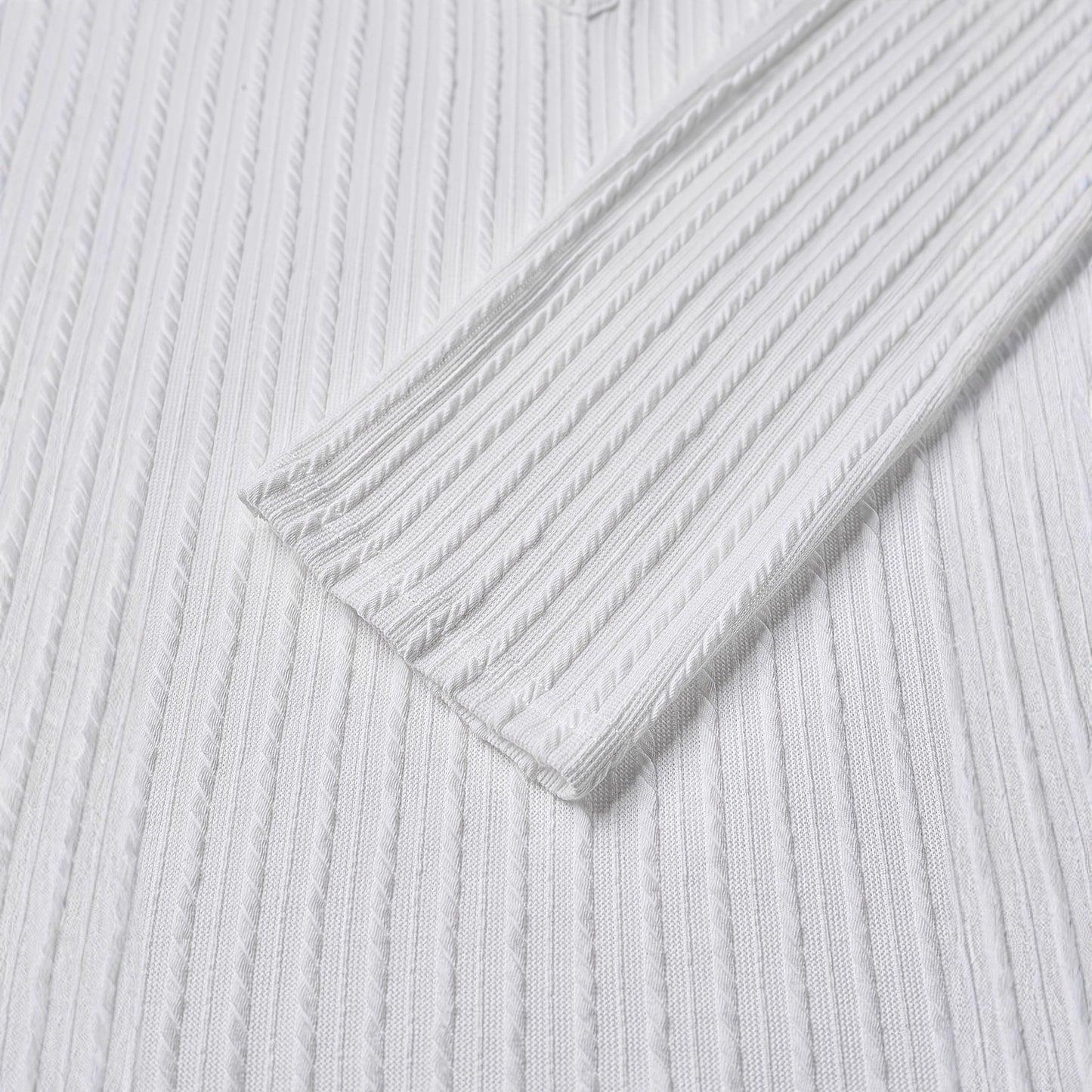 Camisa de malha texturizada de cor sólida com gola redonda e mangas compridas com botões.